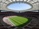 Aerial view of iconic European sports stadium with pristine turf and modern engineering roof structure